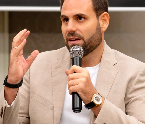 Jose M. Romero pictured from the waist up, holding a microphone